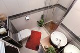 Také v kategorii nejmenších koupelen (do 4 metrů čtverečních) nejlépe uspěl návrh bílé koupelny s tmavými prvky v obložení a dřevěnými detaily ve vybavení.