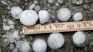 A metering rule is placed beside hailstones after a hail storm hit the city of Zurich July 1, 2012. REUTERS/Arnd Wiegmann (SWITZERLAND - Tags: ENVIRONMENT) Published: Čec. 1, 2012, 9:58 dop.