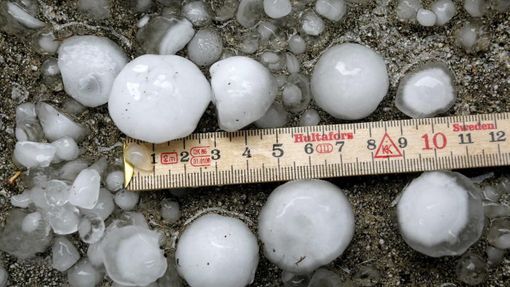 A metering rule is placed beside hailstones after a hail storm hit the city of Zurich July 1, 2012. REUTERS/Arnd Wiegmann (SWITZERLAND - Tags: ENVIRONMENT) Published: Čec. 1, 2012, 9:58 dop.