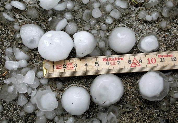 A metering rule is placed beside hailstones after a hail storm hit the city of Zurich July 1, 2012. REUTERS/Arnd Wiegmann (SWITZERLAND - Tags: ENVIRONMENT) Published: Čec. 1, 2012, 9:58 dop.