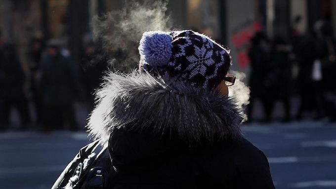 A woman's breath condenses as she is bundled up from the cold and stands along 7th avenue in New York January 23, 2013. An Arctic blast gripped the U.S. Midwest and Northeast on Tuesday, with at least three deaths linked to the frigid weather, and fierce winds made some locations feel as cold as 50 degrees below zero Fahrenheit. (minus 46 degrees Celsius). REUTERS/Shannon Stapleton (UNITED STATES - Tags: ENVIRONMENT SOCIETY) Published: Led. 23, 2013, 3:32 odp.
