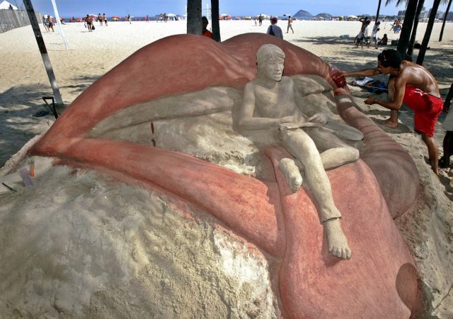 Carlos Pita dokončuje pískovou sochu Micka Jaggera na pláži Copacabana.