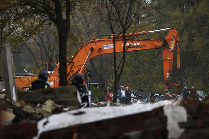 Carmina Gabarri and her husband Victor Valdes watch as a bulldozer demolishes the small school, where they were living at after their own house was demolished, at the Spanish gypsy settlement of Puerta de Hierro, in the outskirts of Madrid November 20, 2012. Fifty-four families have been living in Puerta de Hierro, on the banks of the Manzanares river for over 50 years. Since the summer of 2010, the community has been subject to evictions on the grounds that the dwellings are illegal. Families, whose homes have been demolished, move in with relatives whose houses still remain while the debris keeps piling up around them as more demolitions take place. REUTERS/Susana Vera (SPAIN - Tags: CIVIL UNREST BUSINESS CONSTRUCTION) Published: Lis. 20, 2012, 4:41 odp.