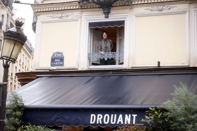 Brigitte Giraudová mává novinářům z okna pařížské restaurace Drouant.