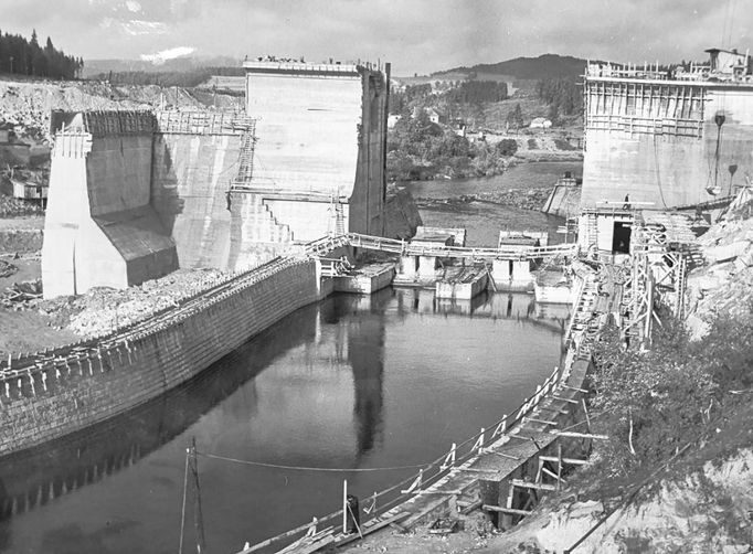 Fotografie ukazuje výstavbu vodní nádrže a elektrárny Lipno, významného díla z roku 1959, které dodává energii a poskytuje rekreační možnosti.