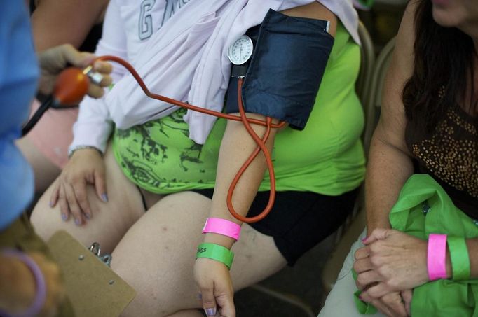 A patient has her blood pressure taken before receiving treatment at the Remote Area Medical (RAM) clinic in Wise, Virginia July 20, 2012. RAM clinics bring free medical, dental and vision care to uninsured and under-insured people across the country and abroad. The Wise clinic was the 647th RAM expedition since 1985 and drew 1700 patients from 14 states, organizers said. Picture taken July 20, 2012. REUTERS/Mark Makela (UNITED STATES - Tags: HEALTH SOCIETY) Published: Čec. 24, 2012, 3:03 odp.