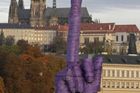 Desetimetrový fialový objekt sem umístil sochař David Černý, který svými uměleckými díly aktuální politickou situaci glosoval v minulosti již několikrát.