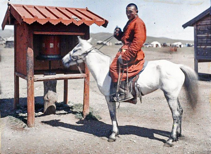 Lama na koni poblíž modlitebního mlýnku. Ulánbátar, Mongolsko, rok 1913