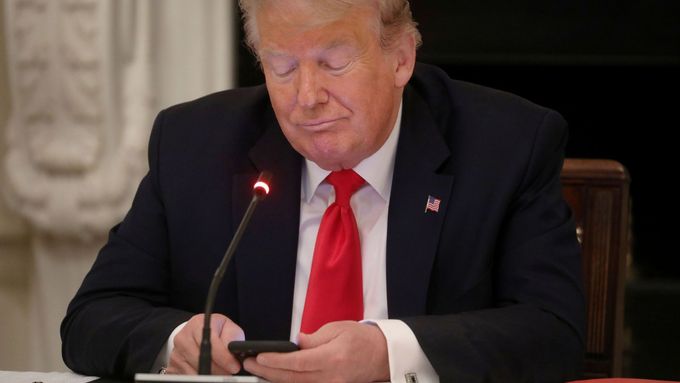Americký prezident Donald Trump na mobilu.