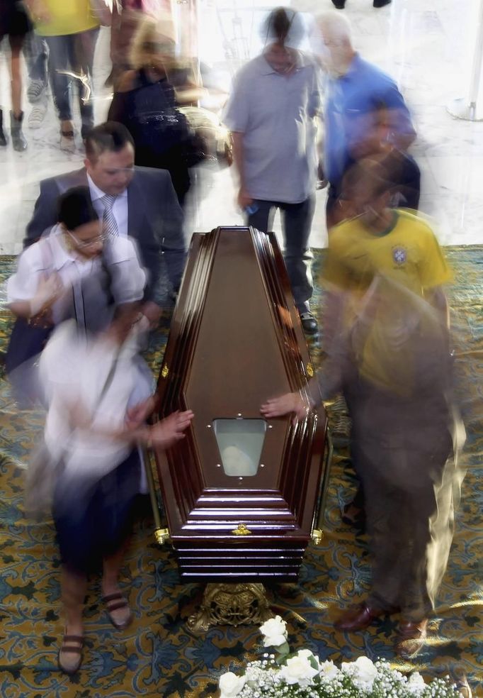 Residents attend the funeral of Oscar Niemeyer at Planalto Palace in Brasilia December 6, 2012. Niemeyer, a towering patriarch of modern architecture who shaped the look of modern Brazil and whose inventive, curved designs left their mark on cities worldwide, died late on Wednesday. He was 104. Niemeyer had been battling kidney and stomach ailments in a Rio de Janeiro hospital since early November. His death was the result of a lung infection developed this week, the hospital said, little more than a week before he would have turned 105. REUTERS/Paulo Whitaker (BRAZIL - Tags: SOCIETY) OBITUARY) Published: Pro. 6, 2012, 10:09 odp.