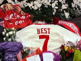 Fotbalový dres George Besta obklopený květinami.