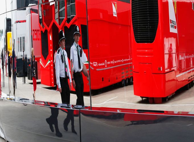 Police officers are reflected in a window as they patrol the paddock before the final practice session for the British Formula One Grand Prix at the Silverstone Race circ