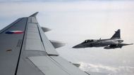 Vládní speciál Airbus 319 CJ s ministrem obrany na palubě je eskortován dvojicí nadzvukových bojových letounů JAS-39C Gripen z 211. taktické letky v Čáslavi. Přibližují se až na pět metrů od křídla.