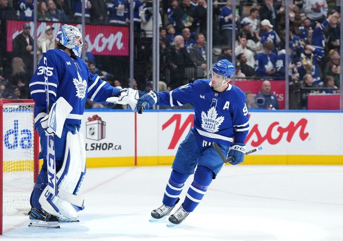 John Tavares slaví gól Toronta s brankářem Dennisem Hildebym.