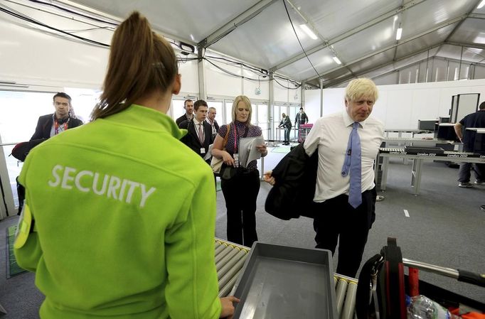 Mayor of London, Boris Johnson, removes his jacket as he passes through a security check during his visit to the 2012 Olympic Park in London July 12, 2012. REUTERS/Scott Heavey/Pool (BRITAIN - Tags: POLITICS SPORT OLYMPICS SOCIETY) Published: Čec. 12, 2012, 5:04 odp.