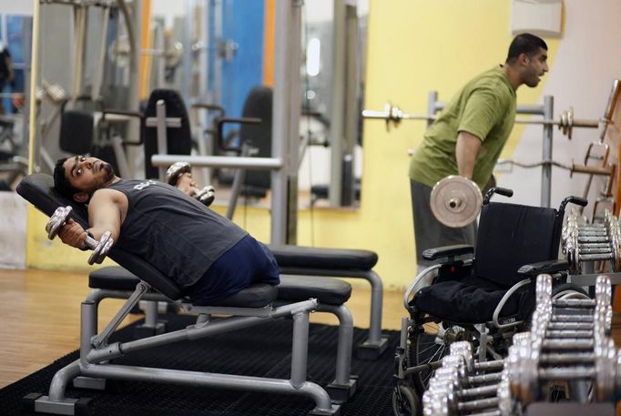 Wheelchair-bound Palestinian freelance photographer Moamen Qreiqea exercises in a gym in Gaza City October 1, 2012. Qreiqea, 25, lost both his legs in an Israeli air strike in 2008 while taking pictures east of Gaza. The father of two is determined to continue his career despite his disability. REUTERS/Suhaib Salem (GAZA - Tags: MEDIA SOCIETY) Published: Říj. 1, 2012, 3:39 odp.