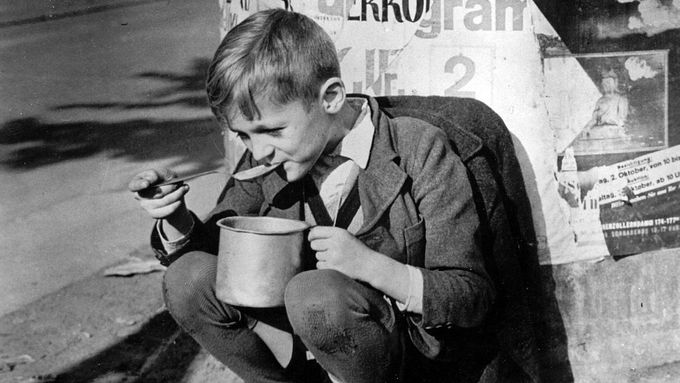 Na ilustračním snímku z roku 1945 je školní dítě v americkém sektoru Berlína s denním přídělem jednoho hrnku polévky.