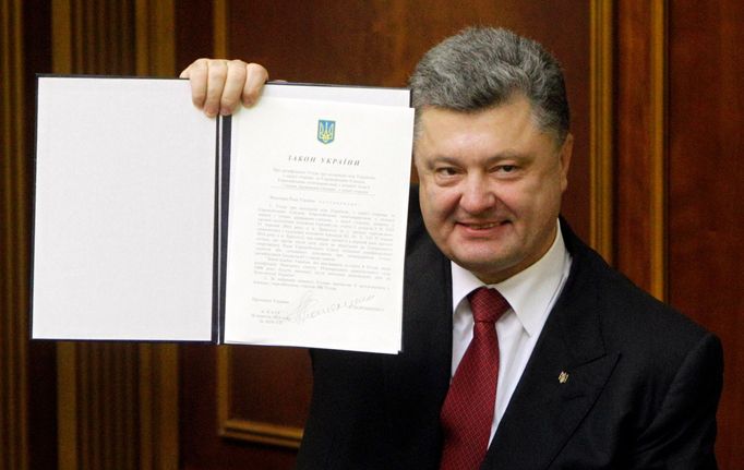 Ukrajinský prezident Petro Porošenko ukazuje podepsanou asociační dohodu s Evropskou unií. Tu v úterý 16. září ratifikovaly parlament i europarlament.