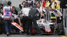 Haas F1 driver Romain Grosjean (R) sits in his car that collided with Manor Racing F1 driver Rio Haryanto at the start of the third practice session at the Australian For