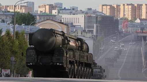 Ruská obrněná vozidla, včetně jednotky mezikontinentálního balistického raketového systému Jars, projíždějí po silnici při nácviku vojenské přehlídky.