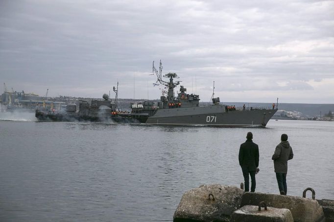 Lidé sledují ruskou námořní loď vplouvající do přístavu ve městě Sevastopol, 2. března 2014.