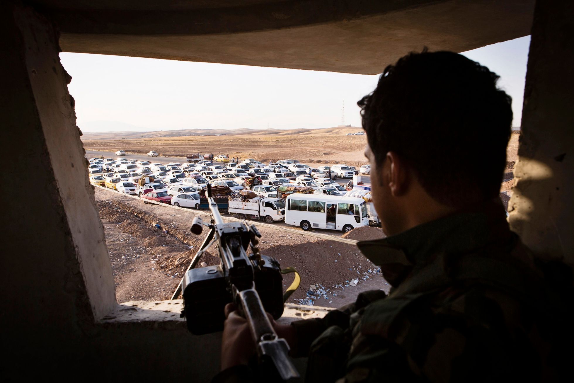 Irácký voják sleduje konvoj uprchlíků z Mosulu.