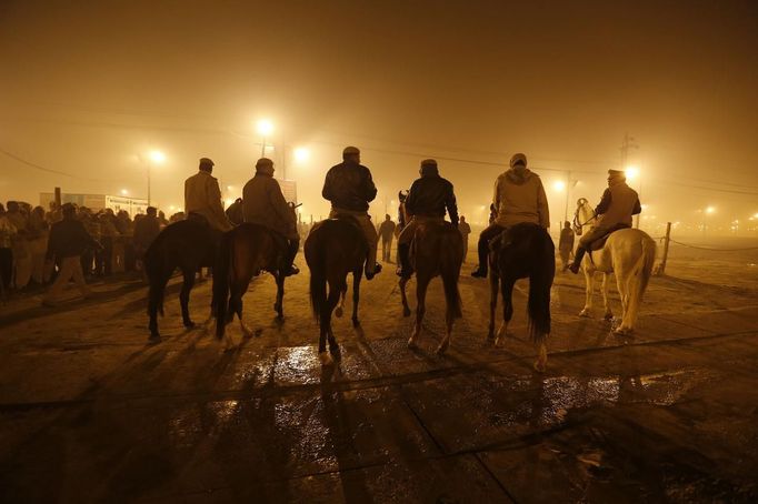 Policemen mounted on their horses patrol during the first "Shahi Snan" (grand bath) at the ongoing "Kumbh Mela", or Pitcher Festival, in the northern Indian city of Allahabad January 14, 2013. Upwards of a million elated Hindu holy men and pilgrims took a bracing plunge in India's sacred Ganges river to wash away lifetimes of sins on Monday, in a raucous start to an ever-growing religious gathering that is already the world's largest. REUTERS/Ahmad Masood (INDIA - Tags: RELIGION SOCIETY ANIMALS) Published: Led. 14, 2013, 1:46 odp.