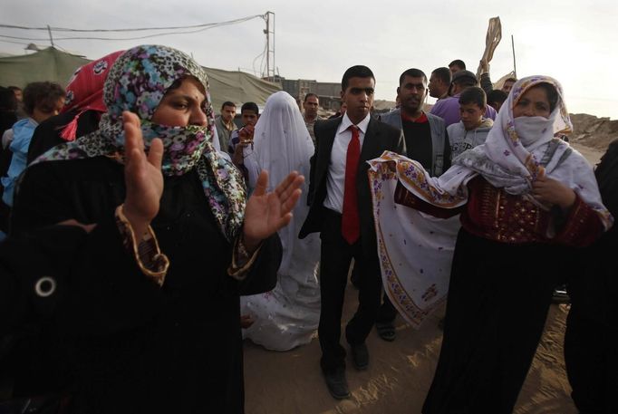 Palestinian groom Emad al-Malalha, 21, walks with Manal Abu Shanar, 17, his Egyptian bride as they arrive from a smuggling tunnel in Rafah in the southern Gaza Strip March 21, 2013. Al-Malaha , who said that his bride was not given a permit from Egyptian authorities to enter the Gaza Strip, brought her from neighboring Egypt through a smuggling tunnel to celebrate his wedding in his native Gaza Strip. REUTERS/Ibraheem Abu Mustafa (GAZA - Tags: POLITICS SOCIETY) Published: Bře. 21, 2013, 6:20 odp.