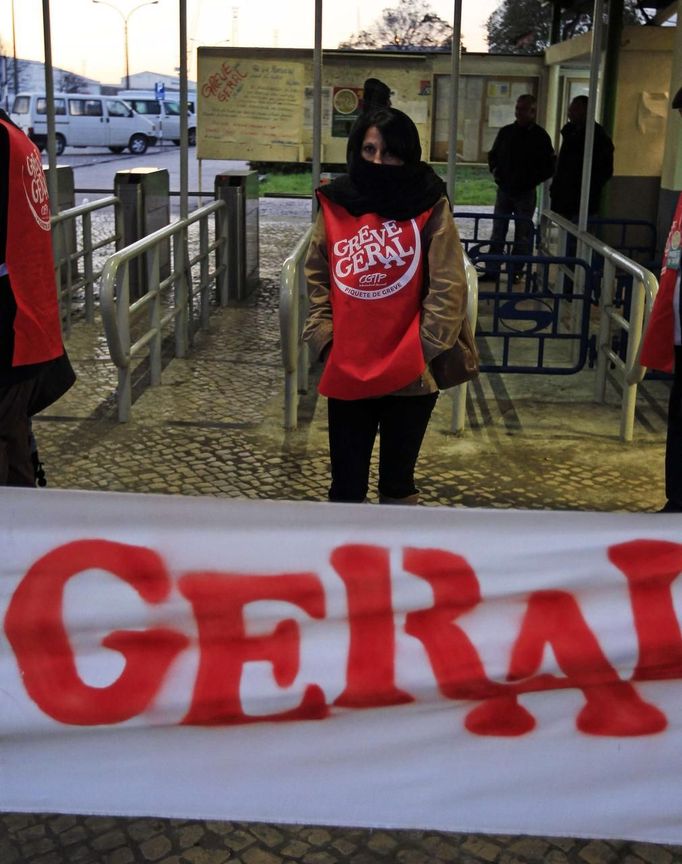 A worker wearing a vest bearing the words "general strike", stays on a picket line on the entrance of Mitrena shipyard, south of Lisbon November 14, 2012. Spanish and Portuguese workers will stage the first coordinated general strike across the Iberian Peninsula on Wednesday, shutting transport, grounding flights and closing schools to protest against spending cuts and tax hikes. REUTERS/Jose Manuel Ribeiro (PORTUGAL - Tags: POLITICS BUSINESS EMPLOYMENT CIVIL UNREST MARITIME TRANSPORT) Published: Lis. 14, 2012, 7:33 dop.