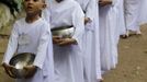 Novice Thai nuns walk in line to receive food at the Sathira Dammasathan Buddhist meditation centre in Bangkok