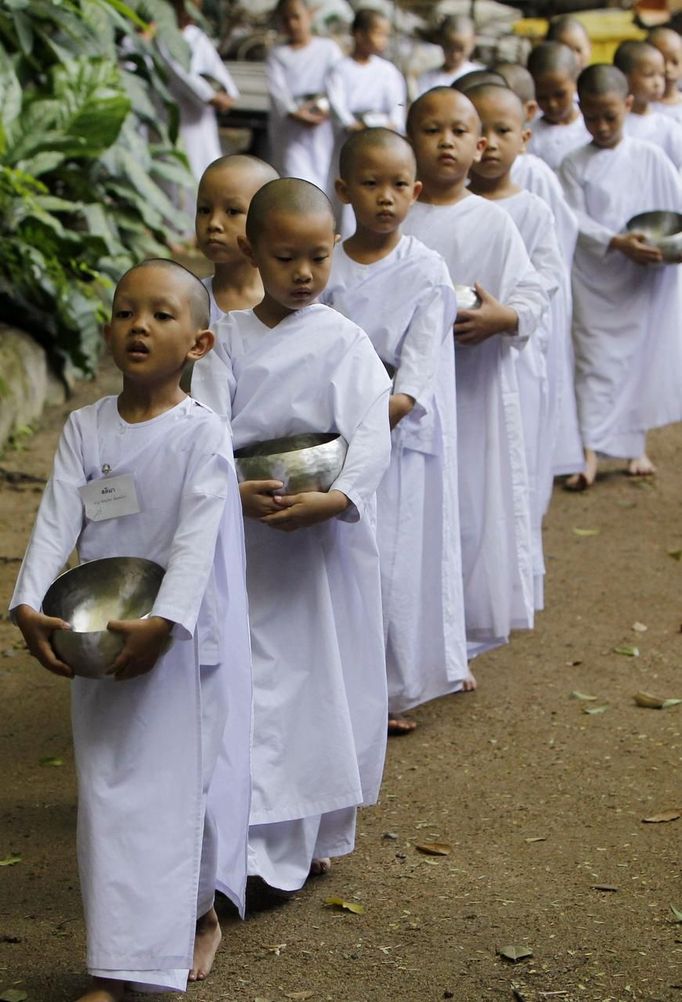 Novice Thai nuns walk in line to receive food at the Sathira Dammasathan Buddhist meditation centre in Bangkok