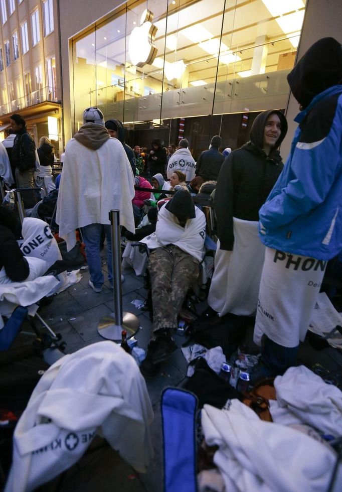 Customers camp outside an Apple store before the release of iPhone 5 in Munich early September 21, 2012. Apple Inc's iPhone 5 hit stores around the globe on Friday, with fans snapping up the device that is expected to fuel a huge holiday quarter for the consumer giant. REUTERS/Michael Dalder (GERMANY - Tags: BUSINESS TELECOMS) Published: Zář. 21, 2012, 7:35 dop.