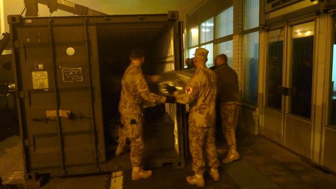 Vojáci vykládají materiál z kontejneru k odbavení do letu