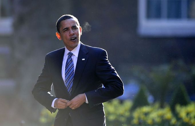 Barack Obama si zapíná sako po vystoupení z limuzíny v Downing Street.