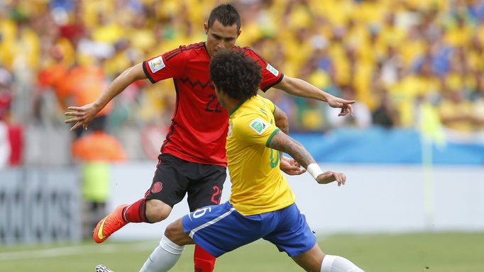 Mexico's Paul Aguilar (L) fights for the ball with Brazil's Marcelo during their 2014 World Cup Group A soccer match at the Castelao arena in Fortaleza June 17, 2014. REU