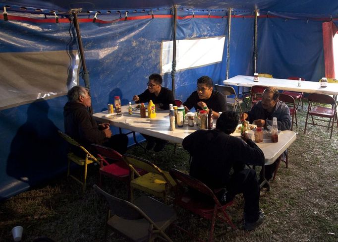 A tent crew eats in the mess tent at Cole Brothers Circus of the Stars during its stop in Myrtle Beach, South Carolina, March 31, 2013. The circus prepares 3 meals a day for the 70 workers that travel with the circus. Traveling circuses such as the Cole Brothers Circus of the Stars, complete with its big top tent, set up their tent city in smaller markets all along the East Coast of the United States as they aim to bring the circus to rural areas. The Cole Brothers Circus, now in its 129th edition, travels to 100 cities in 20-25 states and stages 250 shows a year. Picture taken March 31, 2013. REUTERS/Randall Hill (UNITED STATES - Tags: SOCIETY ENTERTAINMENT) Published: Dub. 1, 2013, 7:01 odp.