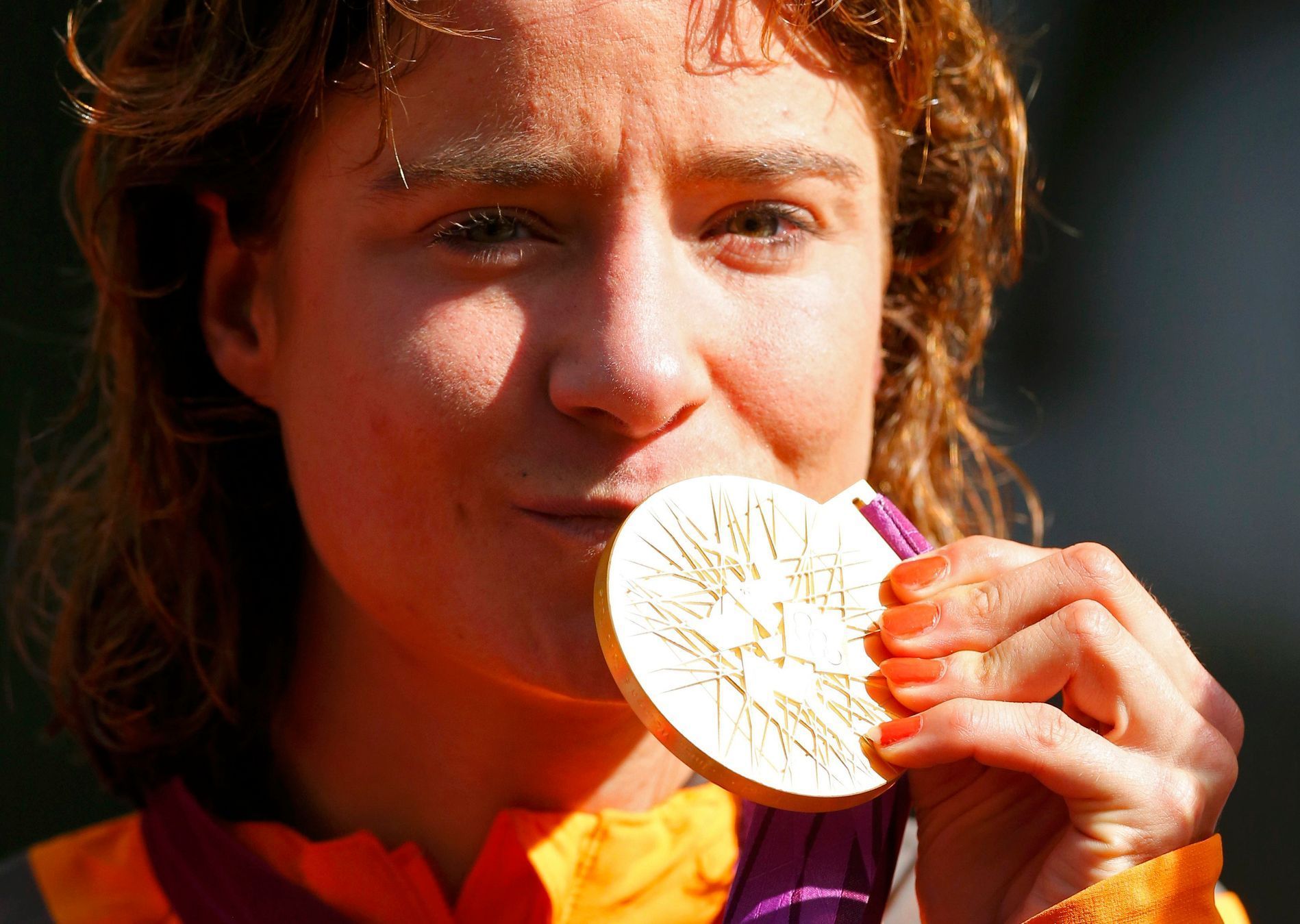 Holandská silniční cyklistka Marianne Vosová líbá zlatou olympijskou medaili po vítězství na OH 2012 v Londýně.