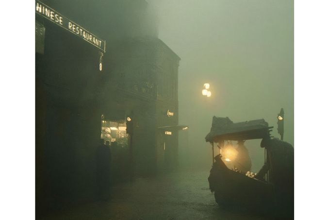 Mlha v Piccadilly, Londýn, 7. prosince 1952. Prodavač ovoce s lampou osvětluje ulici v temnotě, zatímco obyvatelé se ztráceli v chaotické noci. Kolorováno