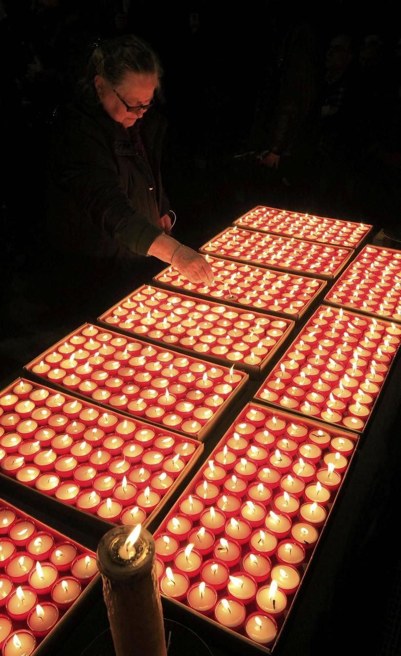 Lidé na vzpomínkové akci v Lovani, zapalování svíček