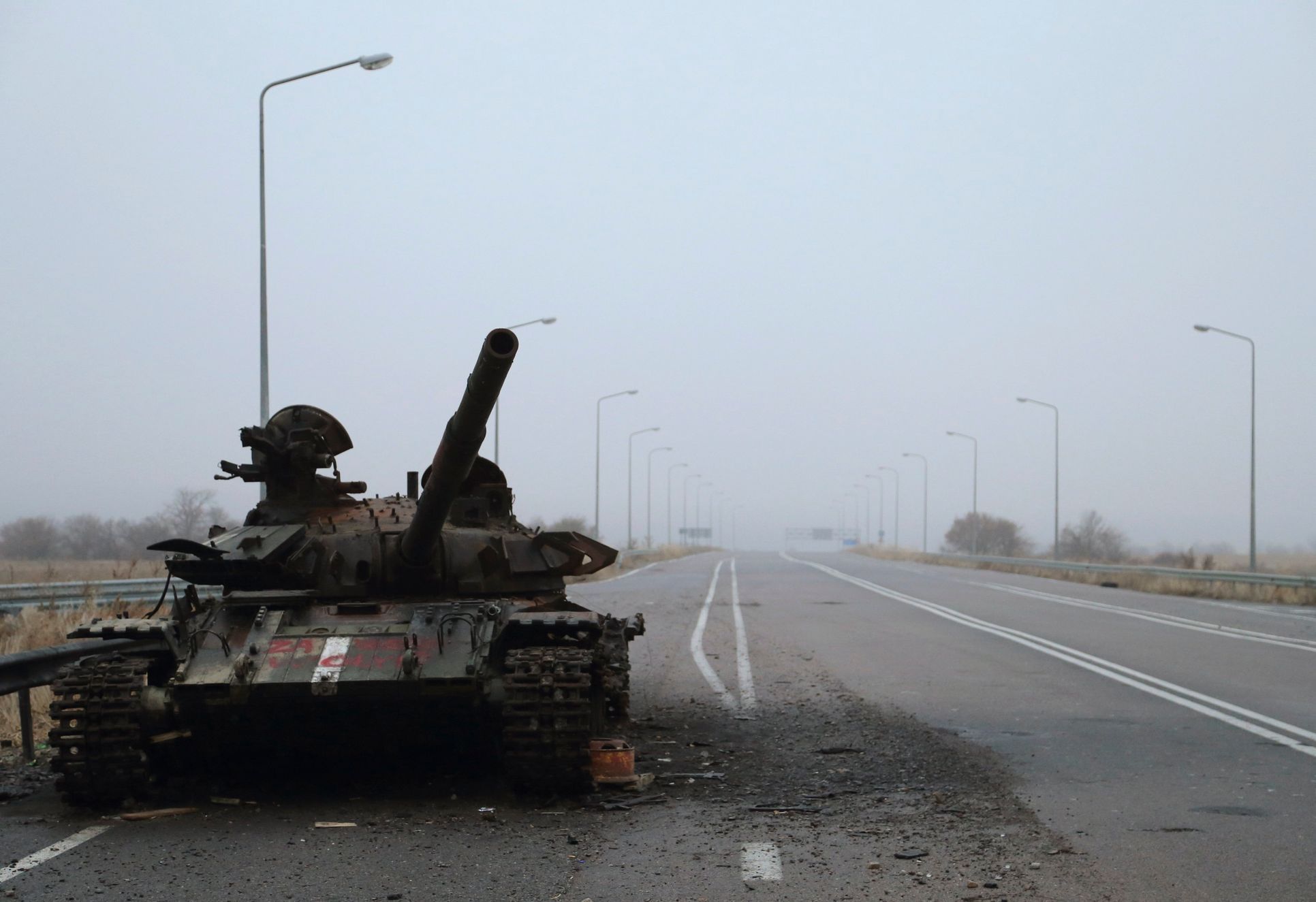 Vrak tanku na silnici u Luhansku.