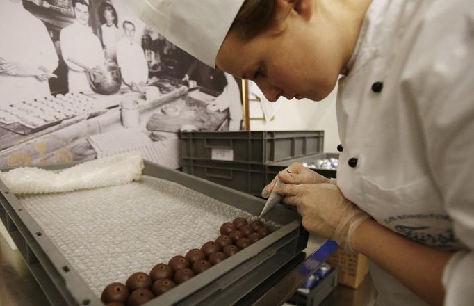 A confectioner produces original Salzburger Mozartkugeln in the confectionery 'Fuerst' in the Austrian city of Salzburg October 19, 2012. The confectionery Fuerst invented the original Salzburger Mozartskugeln, named by the famous composer Wolfgang Amadeus Mozart, in 1884 and still produces 2,5 millions Mozartskugeln per year exclusively by hand. REUTERS/Dominic Ebenbichler (AUSTRIA - Tags: FOOD SOCIETY) Published: Říj. 19, 2012, 3:36 odp.