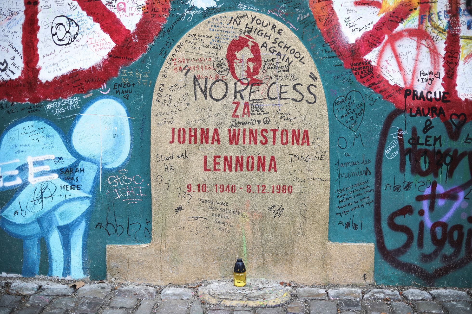 Lennonova zeď po třech měsících od malování - turisté, graffiti