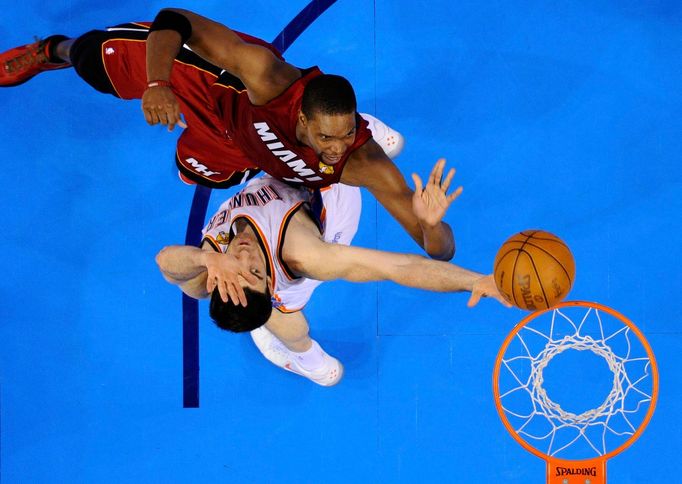 Nick Collison vypichuje z obroučky míč po nájezdu Chrise Boshe.