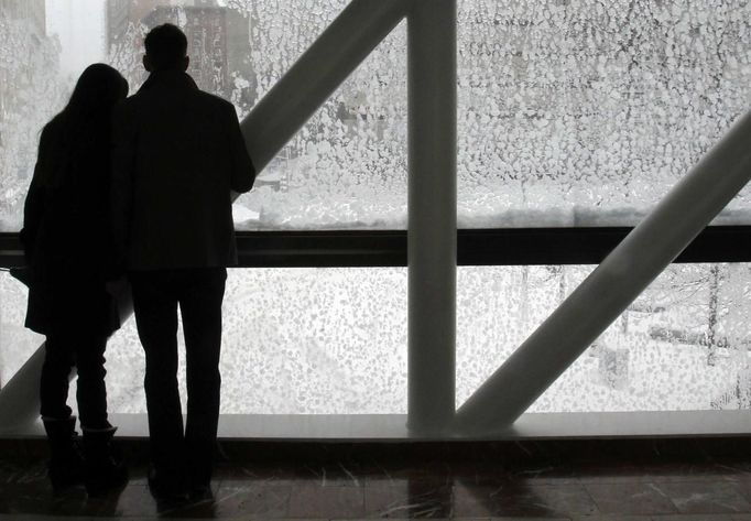 ¨ A couple looks out of a snow covered window onto the street during a blizzard in Boston, Massachusetts February 9, 2013. REUTERS/Jessica Rinaldi (UNITED STATES - Tags: ENVIRONMENT) Published: Úno. 9, 2013, 5:59 odp.