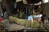 Izraelský voják odpočívá, zatímco jeho jednotka čeká při hranicích s Libanonem na povel k případné ofenzivě.