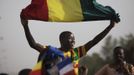 A Malian man waves a Mali flag as France's President Francois Hollande (not pictured) speaks at Independence Plaza in Bamako, Mali February 2, 2013. France will withdraw its troops from Mali once the Sahel state has restored sovereignty over its national territory and a U.N.-backed African military force can take over from the French soldiers, Hollande said on Saturday. REUTERS/Joe Penney (MALI - Tags: POLITICS CONFLICT) Published: Úno. 2, 2013, 8:07 odp.