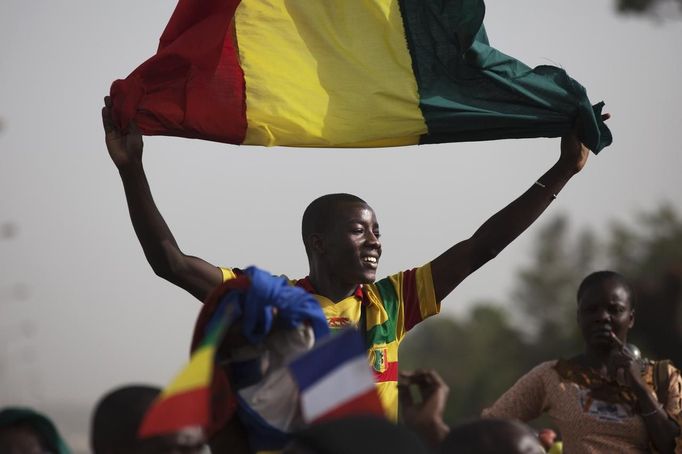 A Malian man waves a Mali flag as France's President Francois Hollande (not pictured) speaks at Independence Plaza in Bamako, Mali February 2, 2013. France will withdraw its troops from Mali once the Sahel state has restored sovereignty over its national territory and a U.N.-backed African military force can take over from the French soldiers, Hollande said on Saturday. REUTERS/Joe Penney (MALI - Tags: POLITICS CONFLICT) Published: Úno. 2, 2013, 8:07 odp.