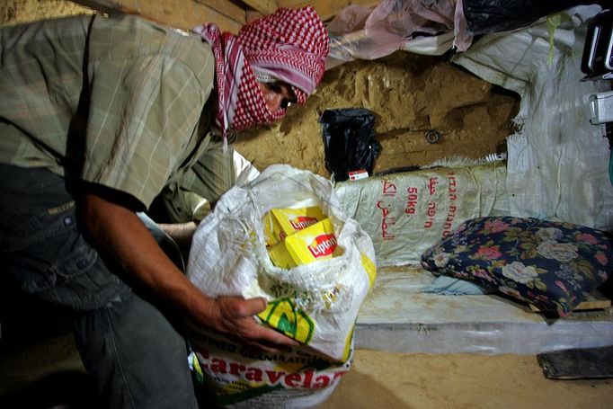 Palestinians carry goods from a tunnel that runs under the border between southern Gaza and Egypt, in the Rafah refugee camp on October 3, 2008. The Egyptian government uncovered and demolished dozens of tunnels running between Egypt and Gaza, reported last week the Israeli newspaper Yediot Aharonot. Palestinians rely on smuggled food and medical supplies through tunnels from Egypt. Israel has closed the crossings with Gaza for legal import goods.