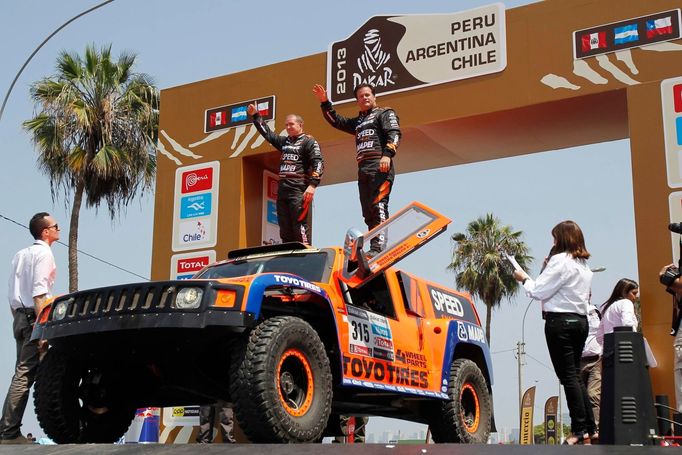 Americký showman Robby Gordon (vpravo) stojí na střeše svého populárního oranžového Hummeru.