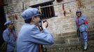 A mid-level government official dressed in red army uniform poses for a picture as she visits an old house where former Chinese leader Mao Zedong used to live during a 5-day training course at the communist party school called China Executive Leadership Academy of Jinggangshan, in Jiangxi province, in this September 21, 2012 file photo. China's Communist Party has dramatically stepped up its training of the country's roughly 40 million party and government officials in the past decade. With public scrutiny of cadre behaviour growing via social media, the party is likely to call for continued, and deepened, cadre education at the upcoming 18th Party Congress. At the vanguard of this education drive, alongside a Central Party School in Beijing, are three "Executive Leadership Academies" which opened in 2005 for middle-ranking and senior officials in Shanghai, Yan'an and Jinggangshan. The curriculum covers Marxism, Leninism and Mao Zedong Thought, but students may also take finance courses, receive in-depth media training or role-play crisis management scenarios on everything from disease outbreaks to train wrecks. REUTERS/Carlos Barria/Files (CHINA - Tags: POLITICS SOCIETY) Published: Zář. 24, 2012, 2:17 odp.